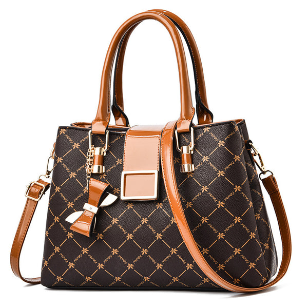 Brown and black patterned handbag with gold accents on a white background